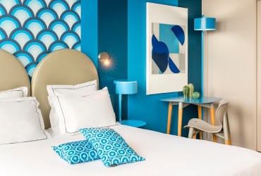 Chambre colorée et moderne de l’Appart’hôtel Appart’City Paris Vélizy, avec une décoration bleue et des éléments design