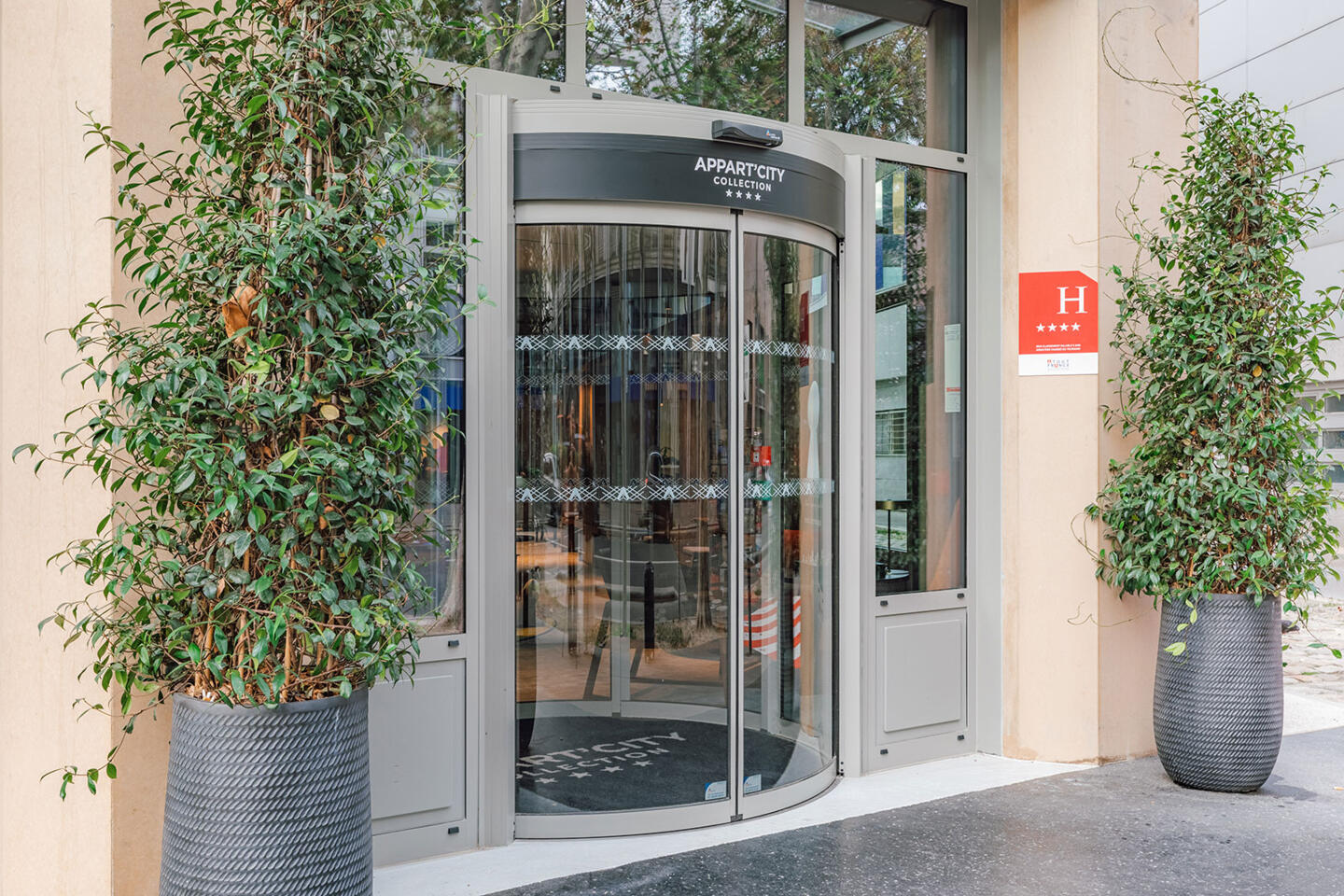 Entrée principale de l'Appart'City Paris Gare de Lyon avec porte tambour et enseigne 4 étoiles.