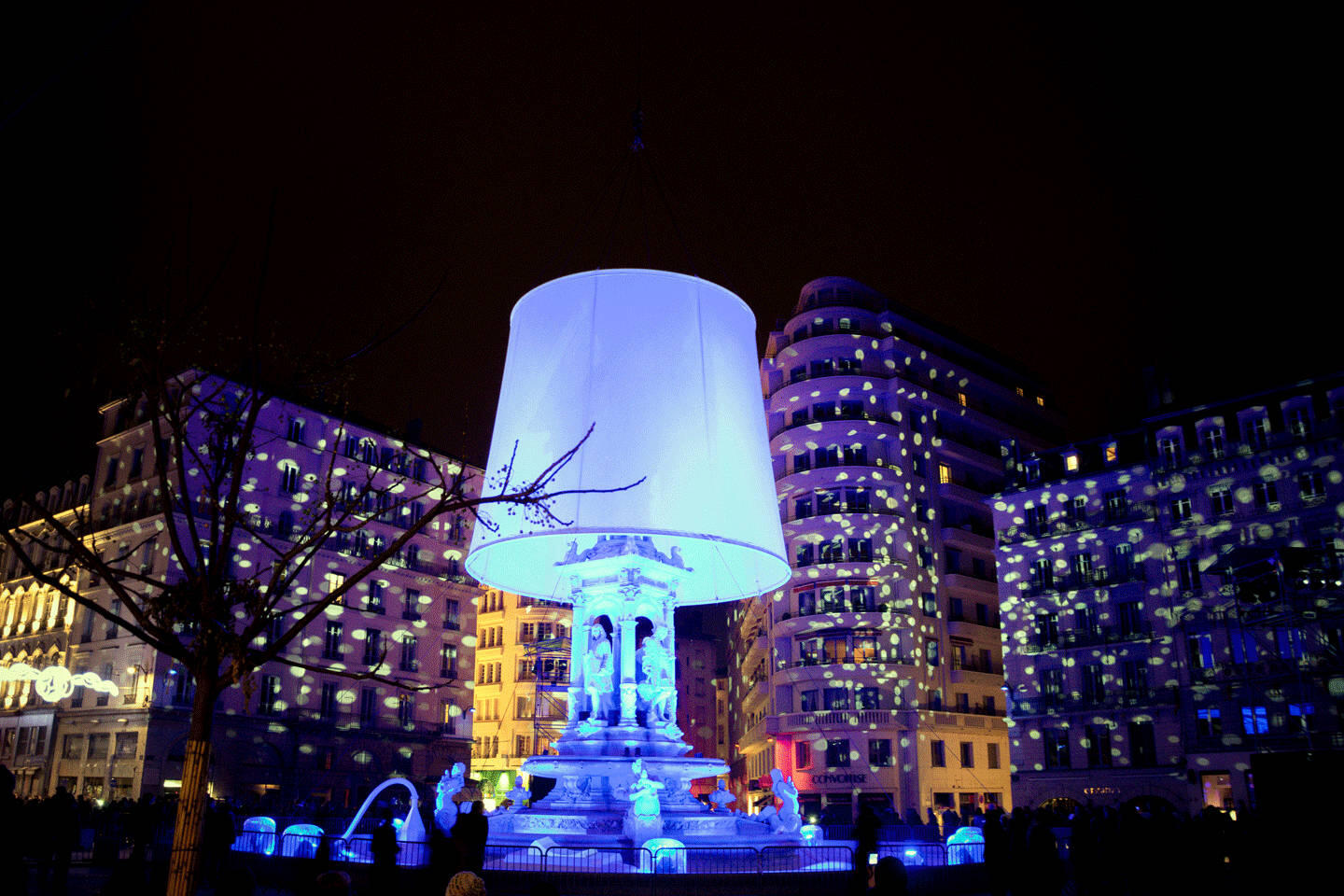 Iluminación nocturna de una plaza emblemática durante el Festival de las Luces en Lyon, cerca del apartahotel Appart'City.